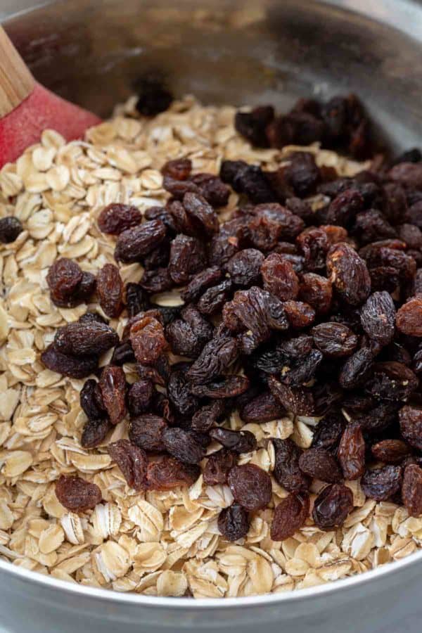 在一个金属搅拌碗里放燕麦和葡萄干