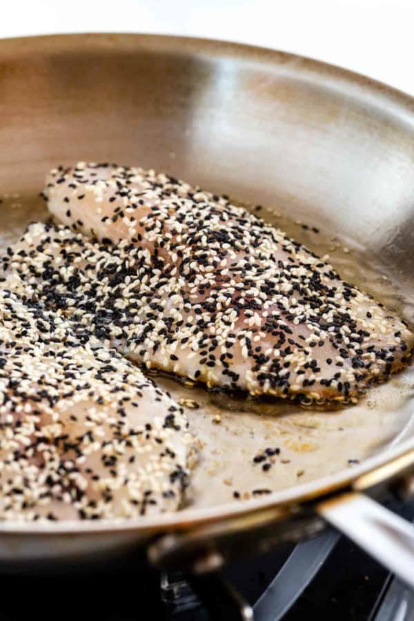 在芝麻籽盖的鱼油煎在平底锅里