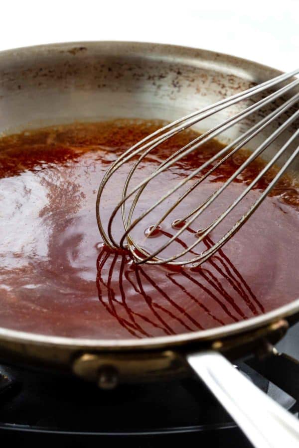 在平底锅中搅拌红色酱汁