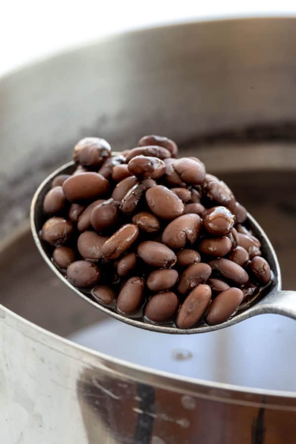 用勺子把煮熟的黑豆从锅里舀出来