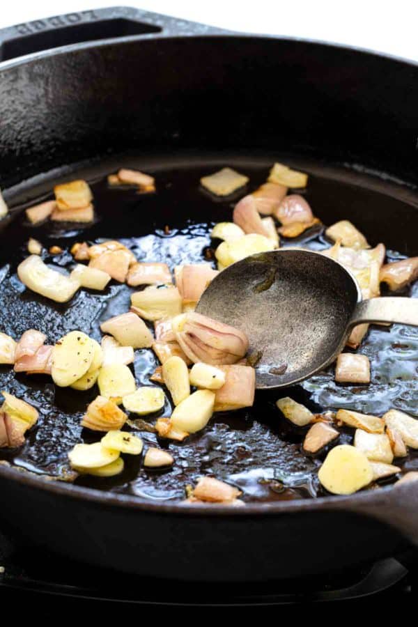 Sautéing洋葱和大蒜在铸铁煎锅