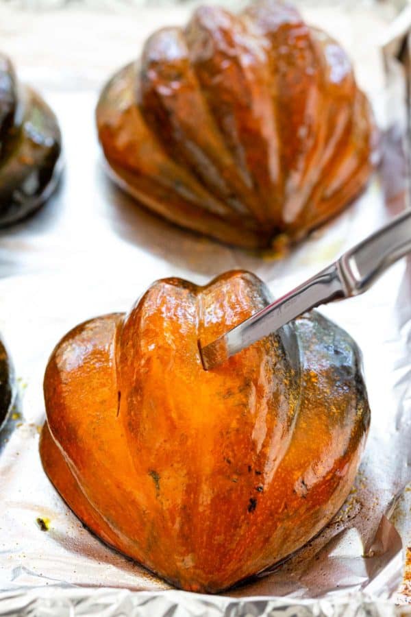 使用刀子刺破烤橡子南瓜的皮肤