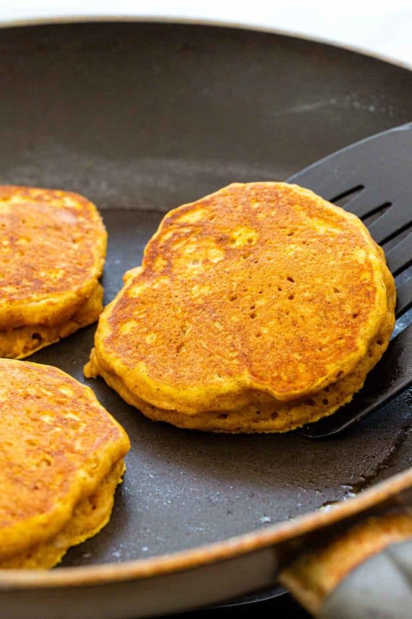 用铲子在平底锅里翻动南瓜饼