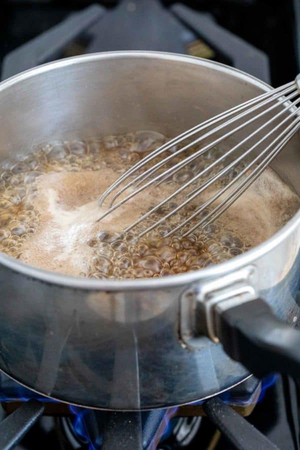 在灶台上的炖锅里搅拌糖浆