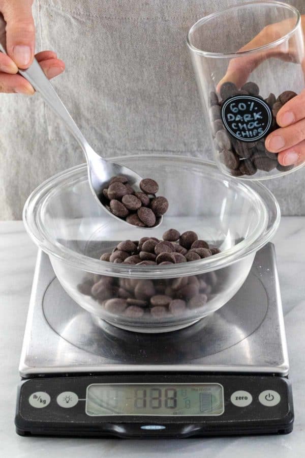 测量在一个玻璃碗里面的巧克力芯片在厨房标度顶部