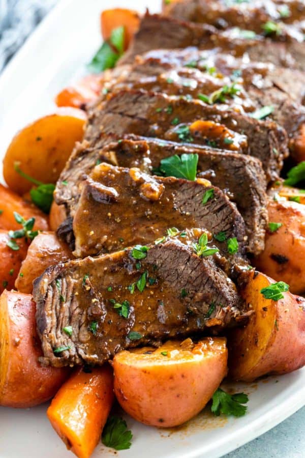 在服务盛肉盘的速溶罐烤切片与根蔬菜