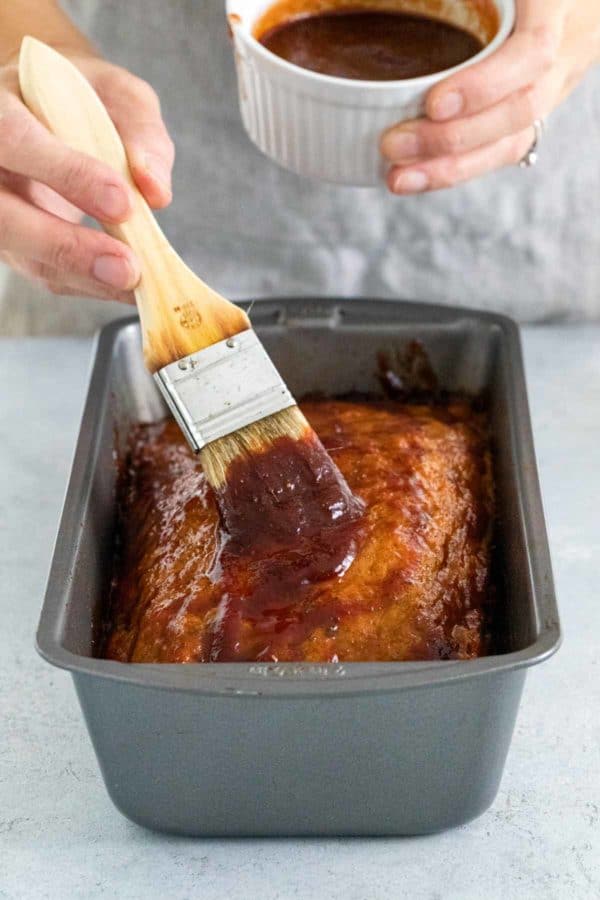 在平底锅里的火鸡肉饼上刷上一层釉料