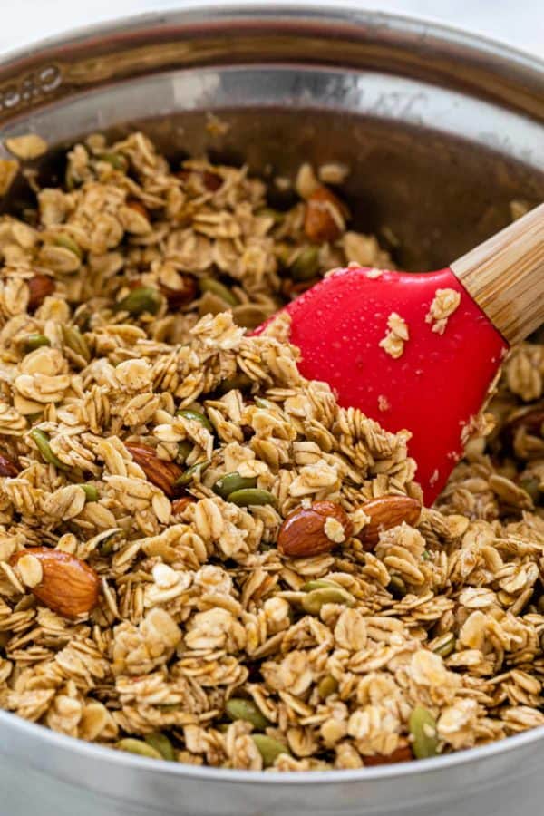 刮刀搅动燕麦和坚果在铝混合的碗里
