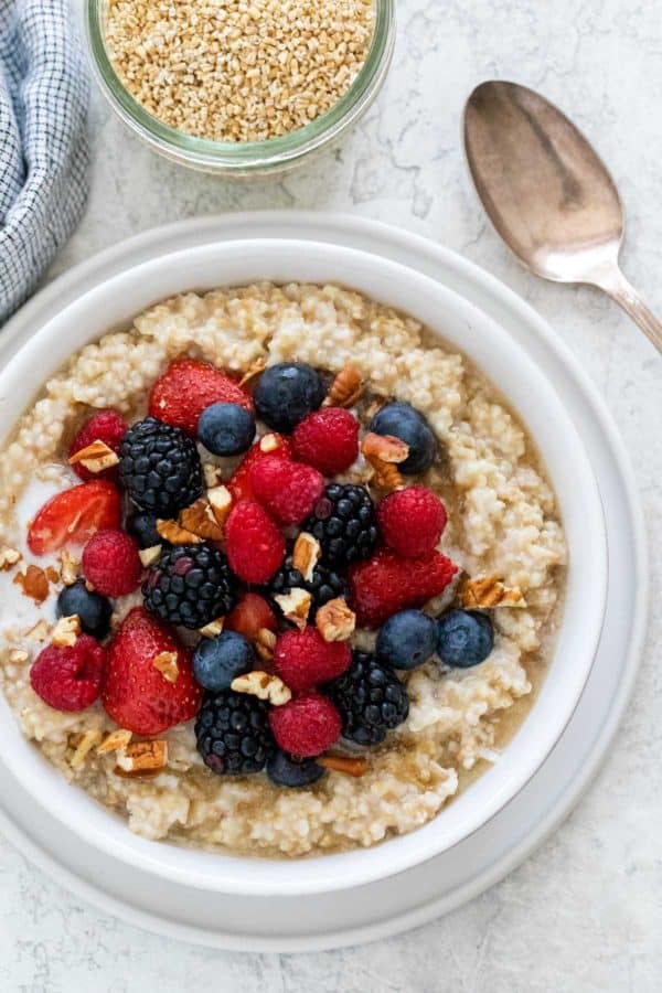 新鲜的蓝莓,覆盆子和切片的草莓冠上了一碗燕麦片