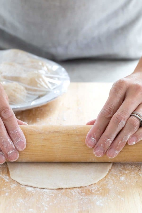 使用擀面杖将面团压成圆玉米饼