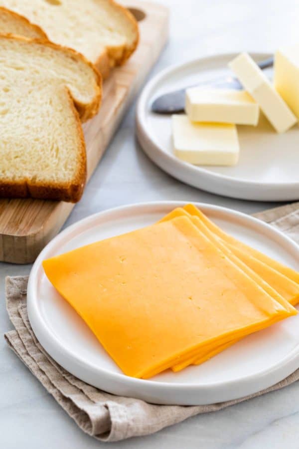桌上有几片奶酪、面包和黄油