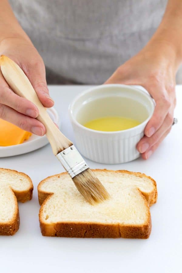 人们在一片白面包上刷融化的黄油