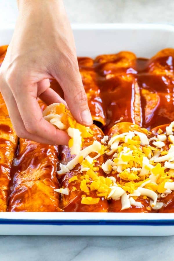 有人在砂锅菜上洒上新鲜磨碎的奶酪