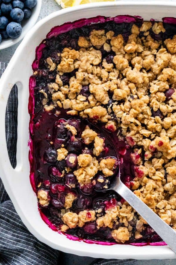 用勺子盛烤盘里的蓝莓酥