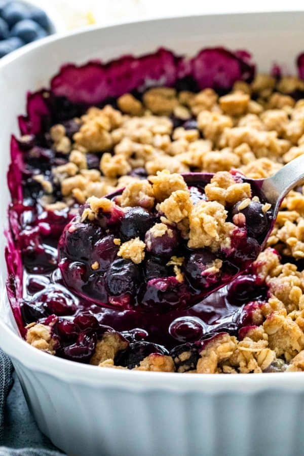 用勺子从热烤盘中舀出蓝莓脆片