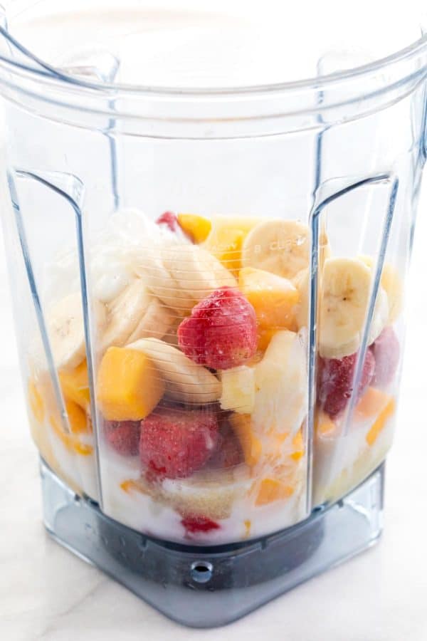 将水果块和冰块放入透明的搅拌器盖中