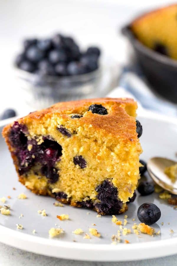 Slice of blueberry cornbread on a white plate