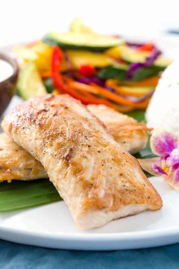 Mahi Mahi鱼平煎饼用酥脆的皮肤在一块板材用蒸蔬菜