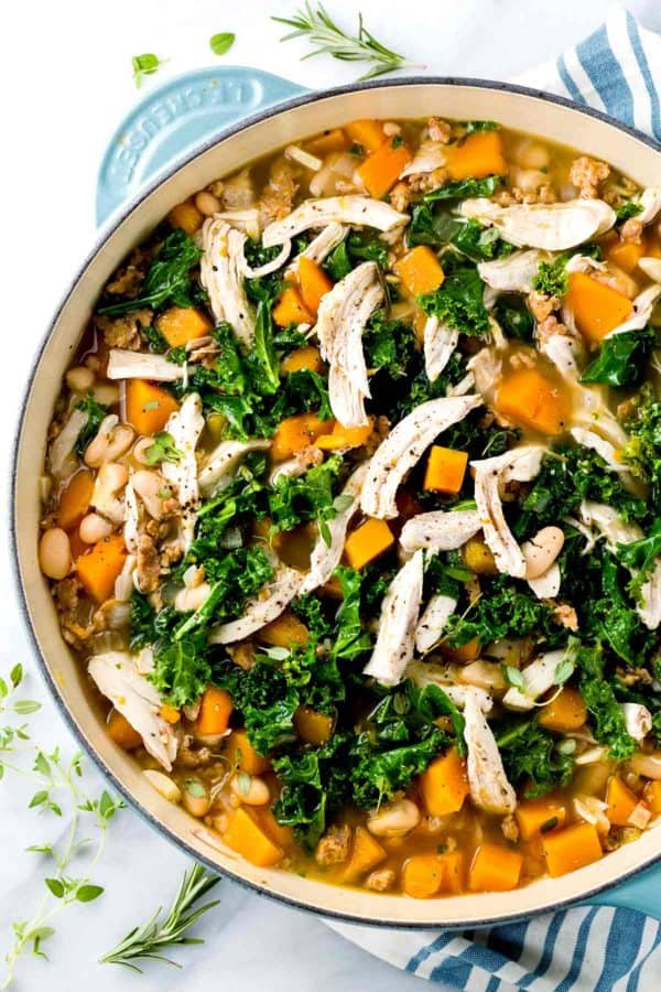 俯视图俯视着一锅开着口的冬南瓜汤，里面有切碎的甘蓝和白肉鸡肉