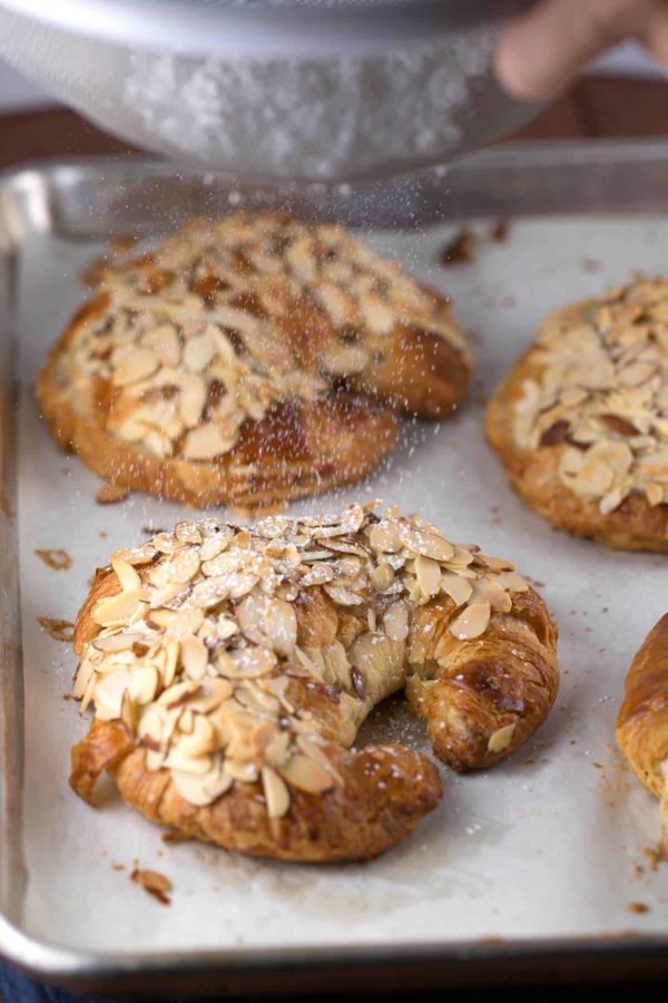 dusting powdered sugar of almond croissants