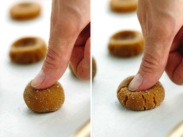 Thumb pressing cookie dough to make indent where the jam will go