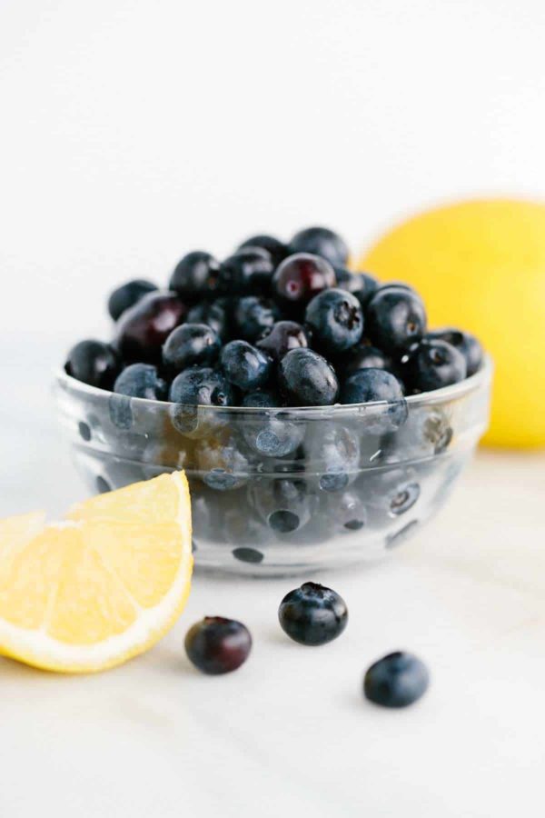 碗蓝莓在切的柠檬楔子旁边