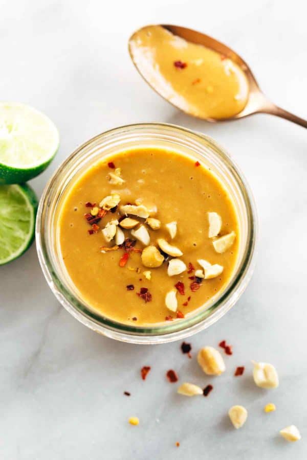 自创花生酱罐和匙子与切碎的坚果在上面