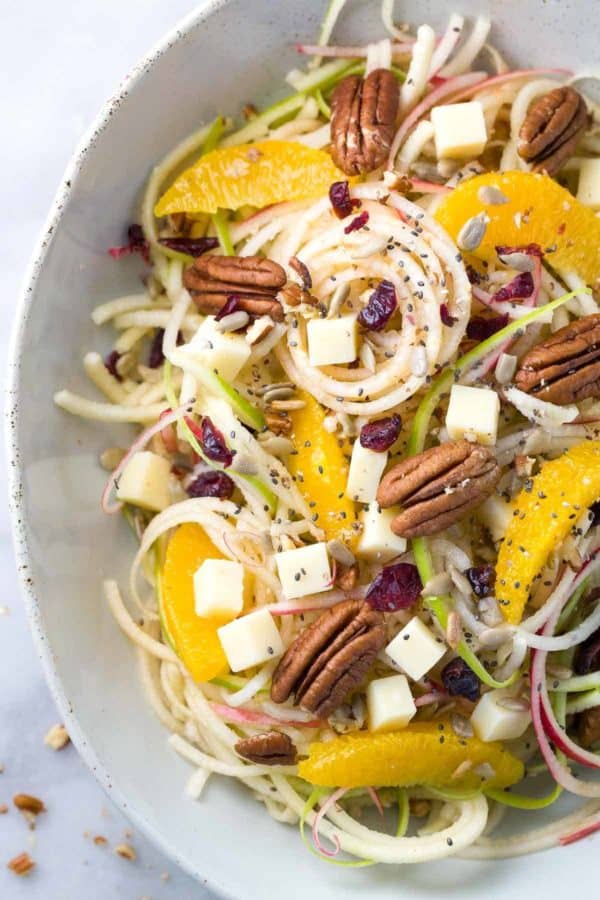 俯视图的螺旋苹果沙拉，坚果，橘子片，奶酪块