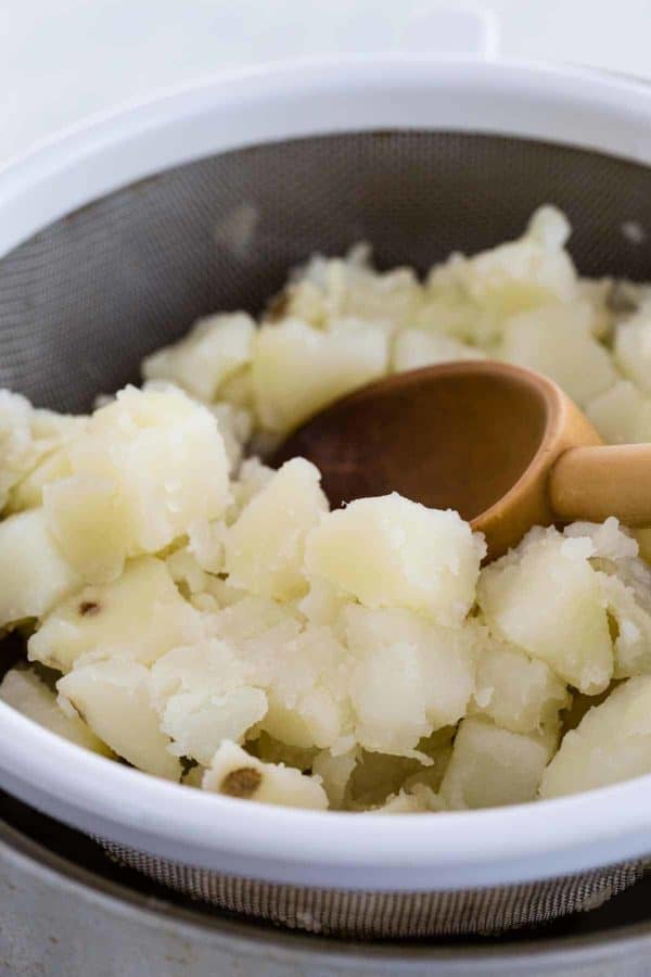 勺子将土豆片推过过滤器