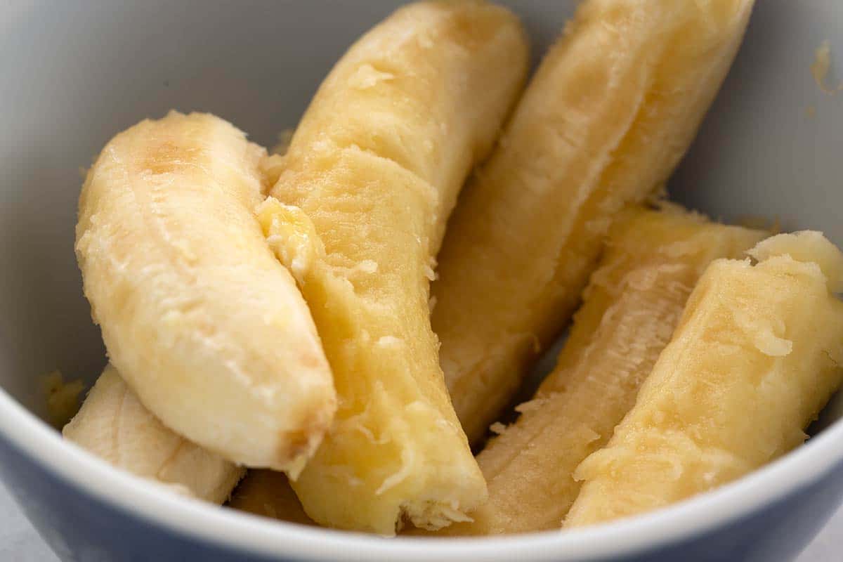 Several peeled bananas in a bowl.