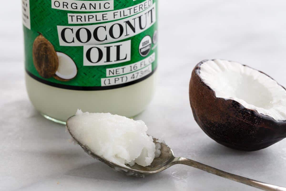 Coconut oil in a jar and on a spoon.