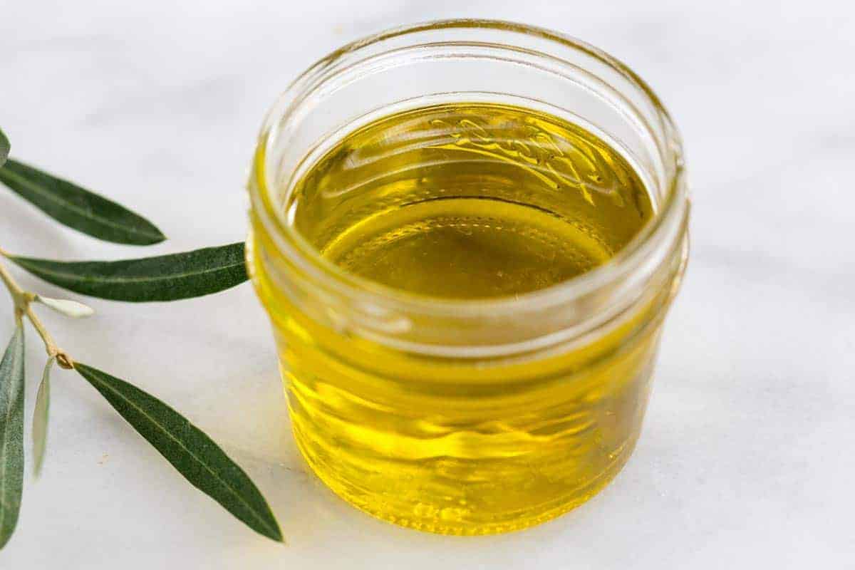 Olive oil in a clear glass jar.