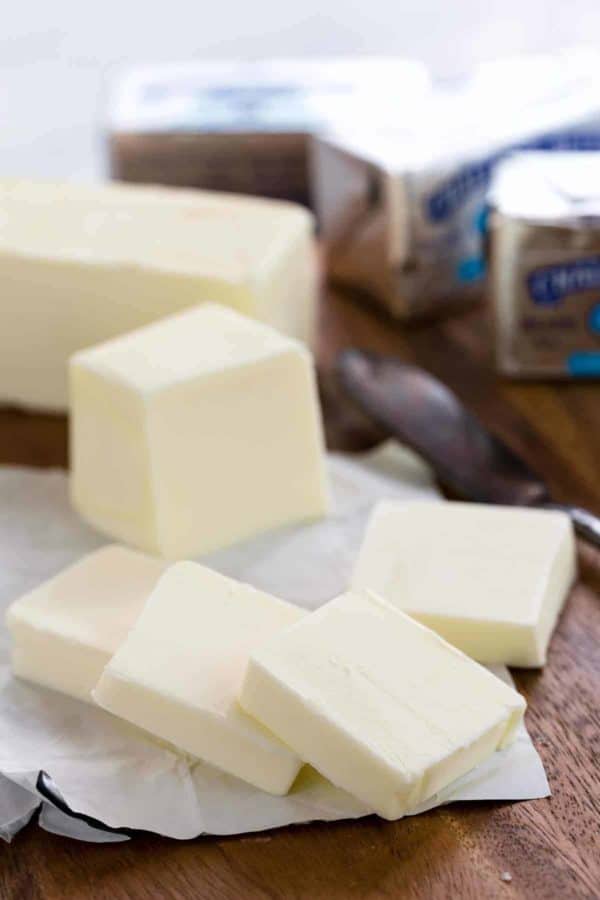 Stick of butter sliced into multiple pieces on a cutting board