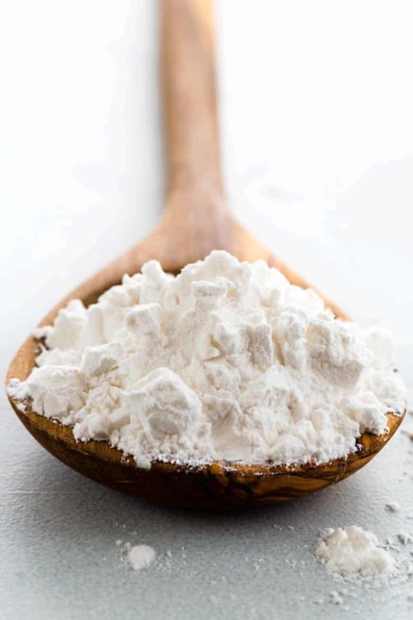 Wooden spoon holding a scoop of arrowroot powder