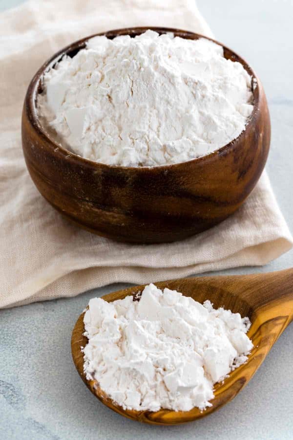 Arrowroot powder in a wooden jar and on a wooden spoon