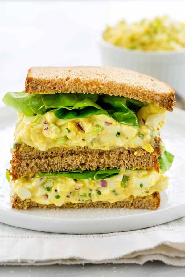 蛋沙拉三明治的照片分裂在中间并且堆积在彼此顶部