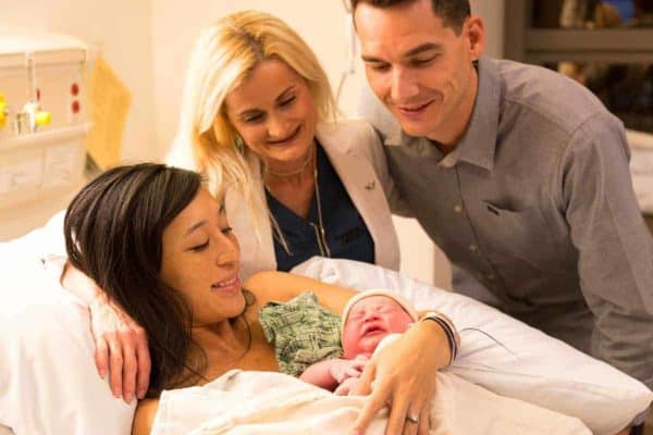 杰西卡抱着奥利维亚，而杰森和医生看他们