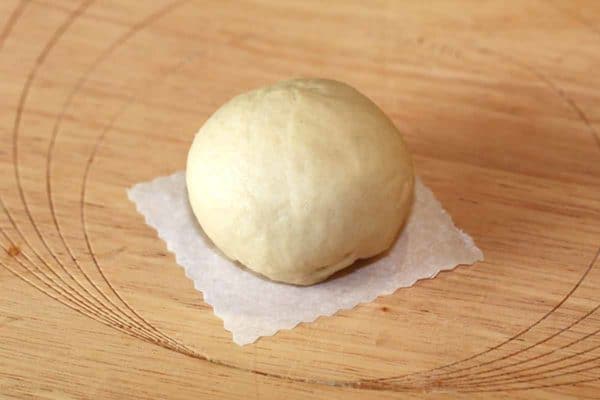 在蒸之前，在方形羊皮纸上放一个圆形的奶油面包