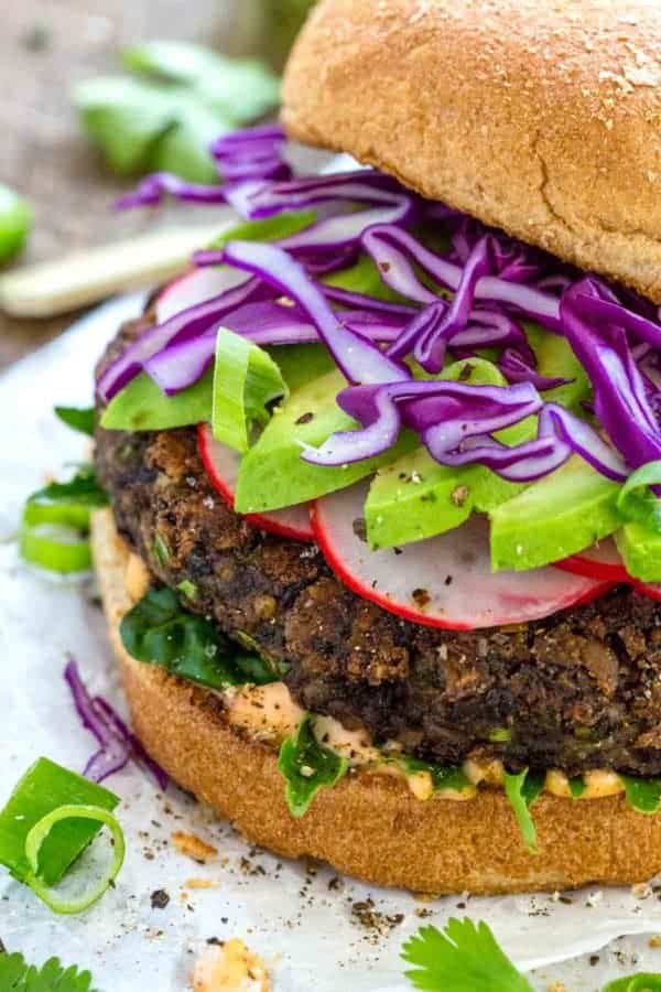 关闭一张黑豆汉堡的照片与鲕梨切片和装饰的