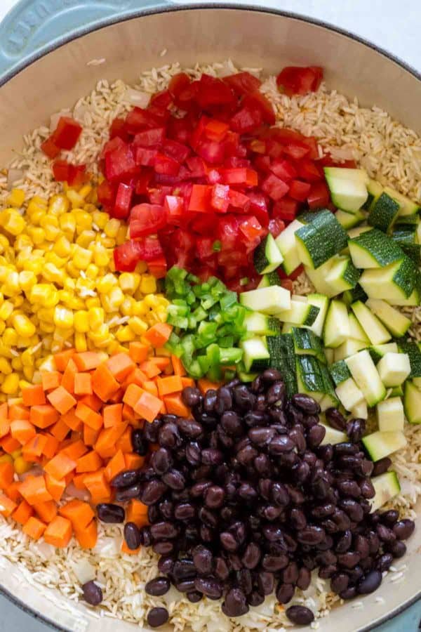 在混合在一起之前，用米饭分配在锅中的蔬菜