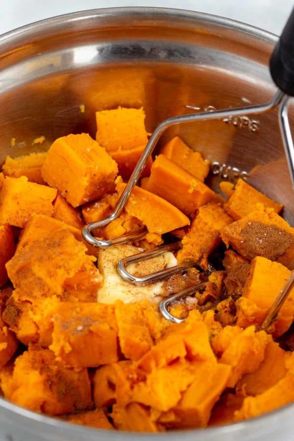 在碗里用土豆捣碎器捣碎红薯块