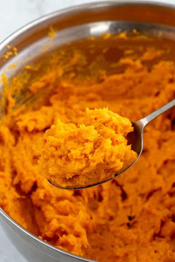 金属勺子从碗里舀出一份土豆泥