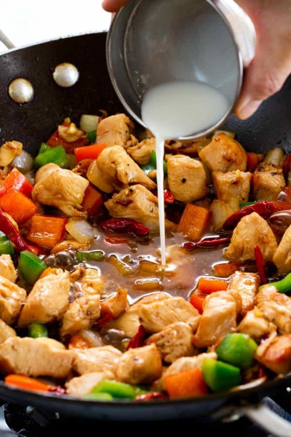 玉米渣浆料倒入一个充满kung pao鸡的炒锅中