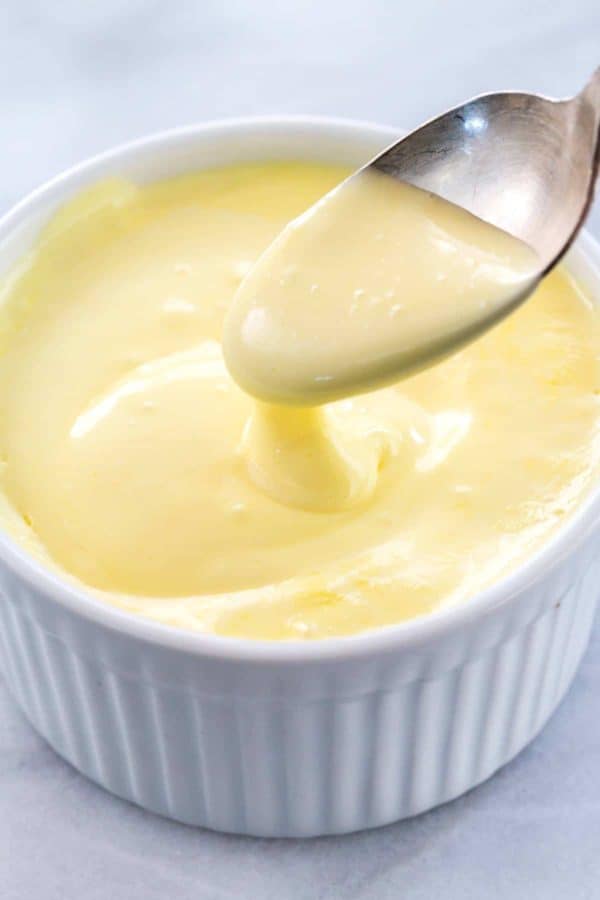 勺子举自制的hollandaise sauce从qamekin