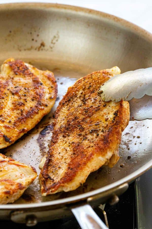 pan searing chicken breasts in a skillet