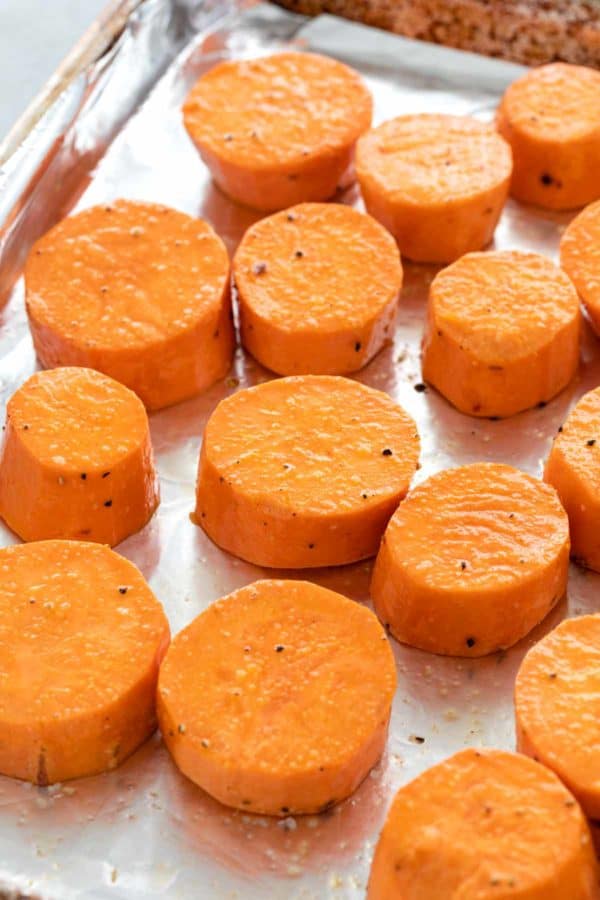 圆切片甜土豆在箔衬里的烘烤板上