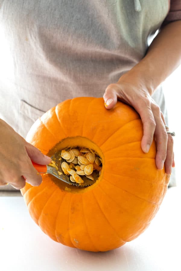 Scooping the seeds out of the bottom of the pumpkin.