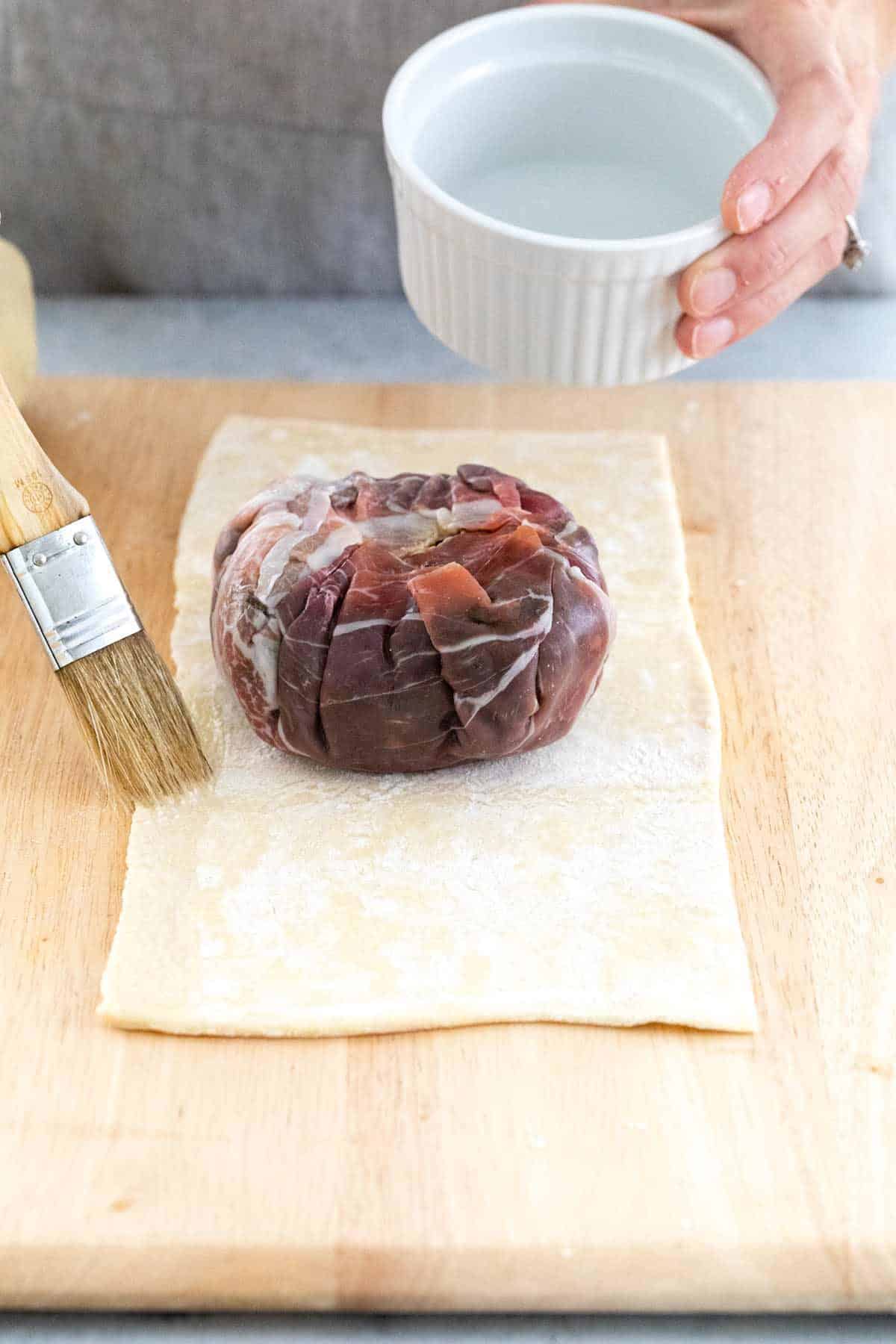 在酥皮糕点的边缘上刷涂水