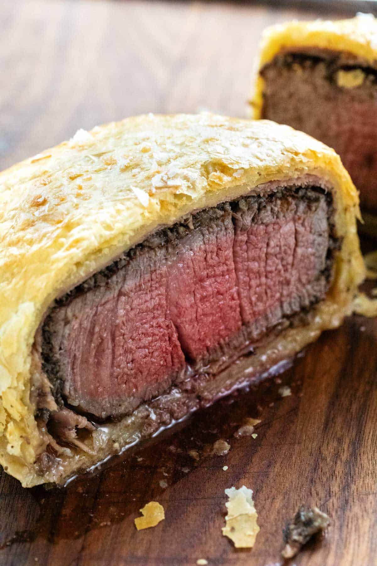 惠灵顿牛肉切成两半，显示一份半熟的牛排