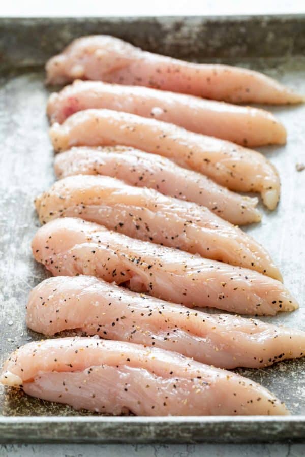 几片调味过的生鸡肉放在托盘上